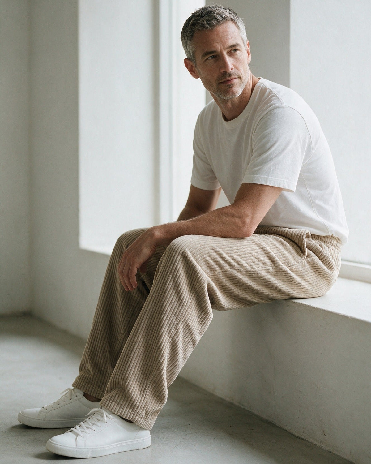 Wexford corduroy trousers in Khaki, sitting by a window